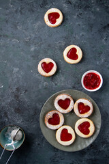 Obraz na płótnie Canvas Round Linzer cookies with red hearts on a dark blue background.
