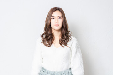 Fototapeta premium 白い壁の前に立つ若い女性