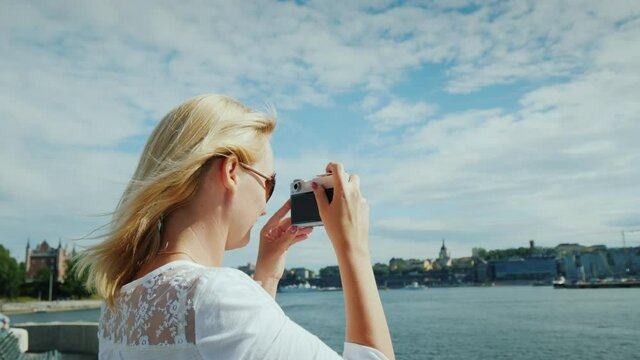 Young woman photographer takes pictures of view of Stockholm