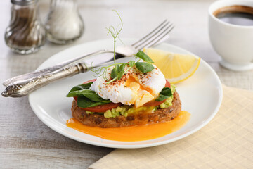  Breakfast. Best Eggs Benedict on a slice of toasted cereal bread with guacamole and spinach