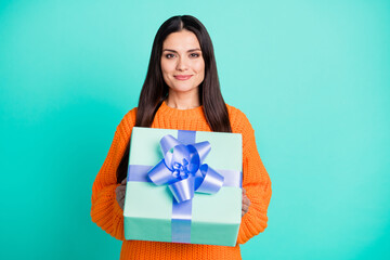 Photo of cheerful lady give you decorated giftbox wear orange sweater isolated teal color background