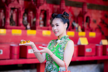 Action portrait beautiful Asian girl wearing Cheongsam green dress. the celebration of something in a joyful and exuberant way. Festivities and Celebration concept