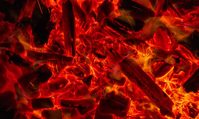 Burning firewood, glowing coals, fire and flames closeup photo. Burning coal for a barbecue
