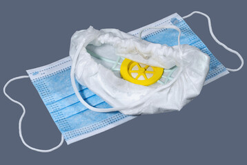 Medical respirator and disposable surgical face mask on dark background