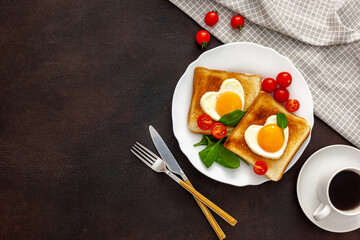Scrambled eggs in the form of heart on plate with tomatoes, greens and coffee