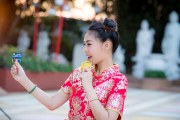 Action pictures of beautiful Asian girls wearing red cheongsam To celebrate something with a fun festival and shopping