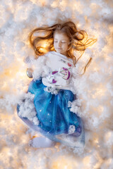 Magic fairy photo. The girl sleeps in fluffy decorative clouds among the magic lights.