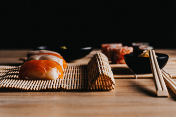 Sushi. Comida japonesa sobre esterilla. Foto de nigiri y maki sushi con luz lateral. Composición de comida asiática.	