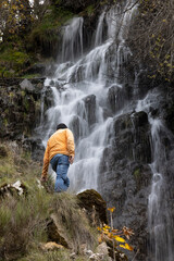 Obraz premium hombre observando cascada en larga exposición