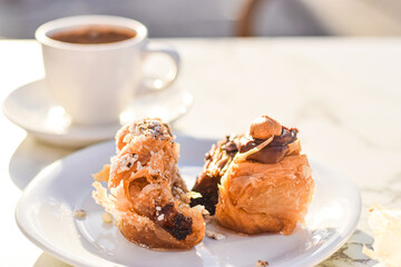Chocolate, hazelnut and pistatio traditional greek baklava cakes served on a plate with coffee, outdoor café  close upbackground