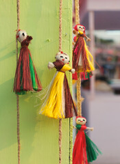 Vibrant multicolor jute dolls, used as wall hanging puppets in a retail display for sale at a...