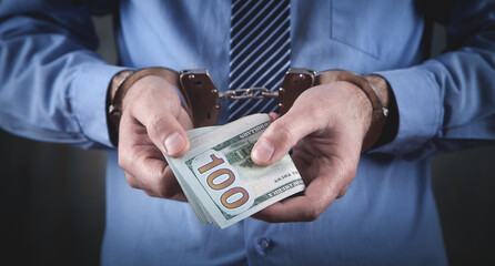 Caucasian businessman in handcuffs and money. Corruption