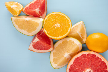 Fototapeta na wymiar Fresh Citrus Fruit. citrus fruits composition and slice on blue background, copy space. top view. Flatlay pattern of citrus orange, lemon, lime and grapefruit slices background.