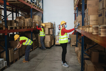 Industrial worker people inside warehouse wearing safety masks for coronavirus prevention - Focus...