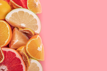 Raw food slicing and whole tropical citrus fruit on pink background.. Fresh citrus fruits background. Top view flat lay copy space.