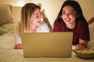 Young girl friends having video call at home using laptop computer during lockdown isolation -