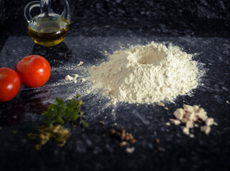 masa de pan o pizza sobre una mesa de piedra con harina creciendo