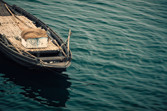Portion of a wooden country boat leisurely floating in calm blue water. Shot on Damodar river in West Bengal.