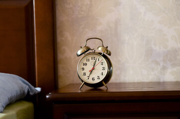 Alarm clock standing on the bedside table.