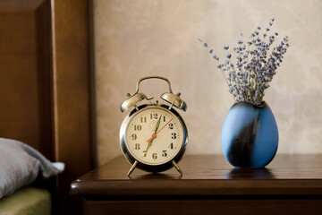 Alarm clock standing on the bedside table.
