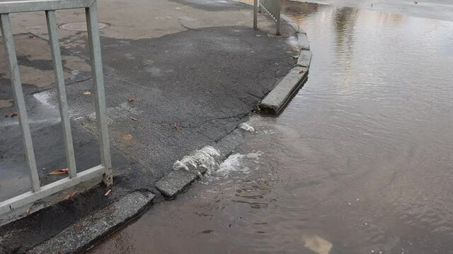 water flows from under the asphalt to the road