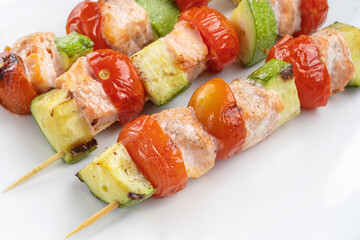 Salmon kebab with zucchini and a beautiful red tomato.
