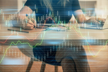 Double exposure of businesswoman hands typing on computer and forex chart hologram drawing. Financial analysis concept.