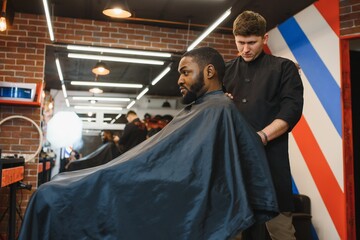 Fototapeta na wymiar Young African-american man visiting barbershop