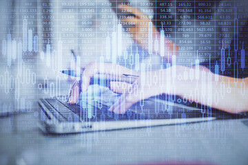 Multi exposure of woman hands typing on computer and financial graph hologram drawing. Stock market...