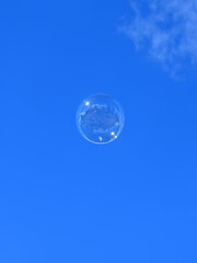 Beautiful soap bubble flies into the blue sky
