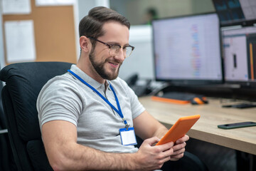 Man in glasses with tablet in chair at workplace