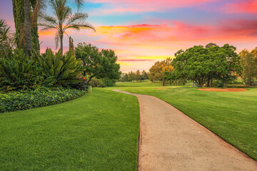 Golf cart pathway in a lush green golf course at sunset © Arnold