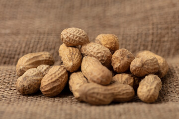 Haufen ungeschälter Erdnüsse auf Jute Stoff