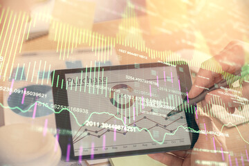 Double exposure of man's hands holding and using a phone and financial chart drawing. Market analysis concept.