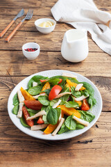Salad of boiled squid, fresh tomatoes, spinach leaves. Delicious bright diet dish with vegetables and seafood.
