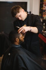 Visiting barbershop. African American man in a stylish barber shop