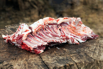 Freshly chopped meat lies on a stump.