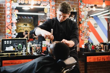 Fototapeta na wymiar Young African-american man visiting barbershop