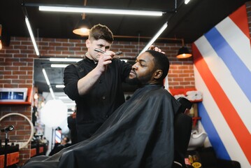 Fototapeta na wymiar Visiting barbershop. African American man in a stylish barber shop