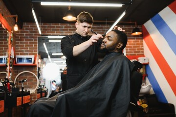Visiting barbershop. African American man in a stylish barber shop