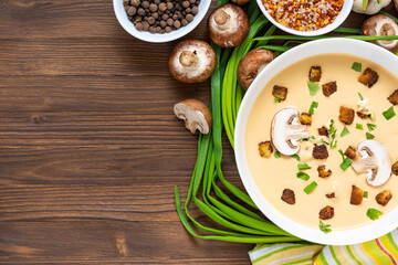 Delicious cream soup, made of mushrooms with croutons on a wooden background. Top view. Copy space.