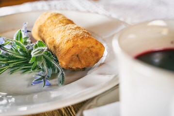 Red borscht with dumplings or a croquette on a plante. Dinner soup on a wooden table. Traditional polish cuisine