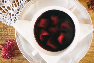 Red borscht with dumplings or a croquette on a plante. Dinner soup on a wooden table. Traditional...
