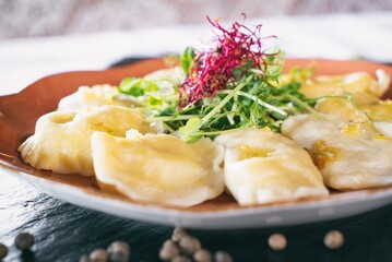 Dumplings with delicious meat on a plante. Dinner main dish on a wooden table. Traditional polish cuisine