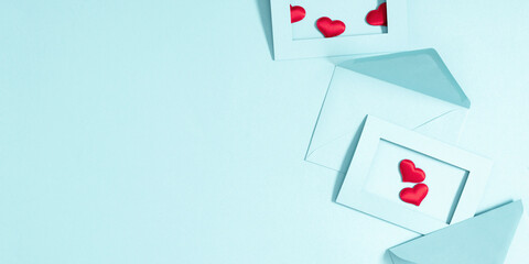 Creative minimal Valentine's Day concept. Envelopes, red hearts confetti, valentines on pastel blue background. Flat lay, top view, copy space