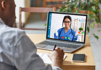 Fototapeta na wymiar Medical services online. African American guy having consultation with doctor on laptop
