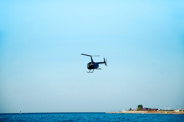 Fototapeta na wymiar Helicopter is flying low over the sea