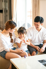 Fototapeta premium Asian mother spend happy family time together for paint her adorable daughter nail at home. Asian family and parenthood concept