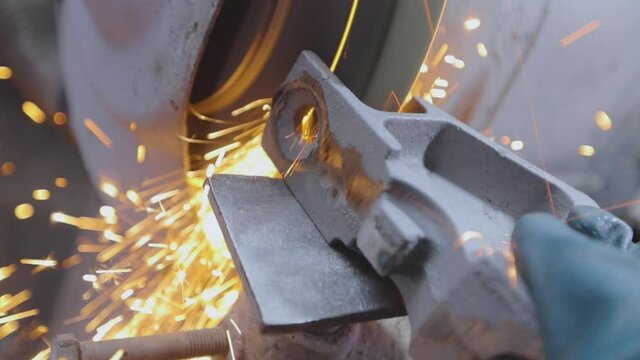 Processing a metal part on a grinding wheel. Bright sparks from machining a metal part. Sparks from grinding a part on a grinding wheel
