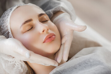 Obraz na płótnie Canvas Cosmetoligist making face procedure. Face lifting massage. Skin care